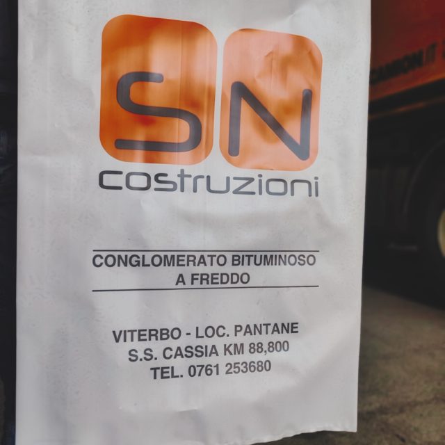 Sacchetto con logo "SN Costruzioni" e informazioni di contatto.