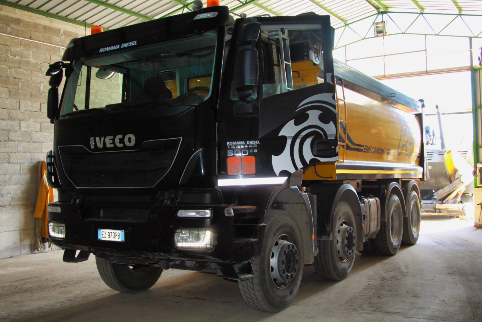Camion Iveco nero e giallo in un garage.