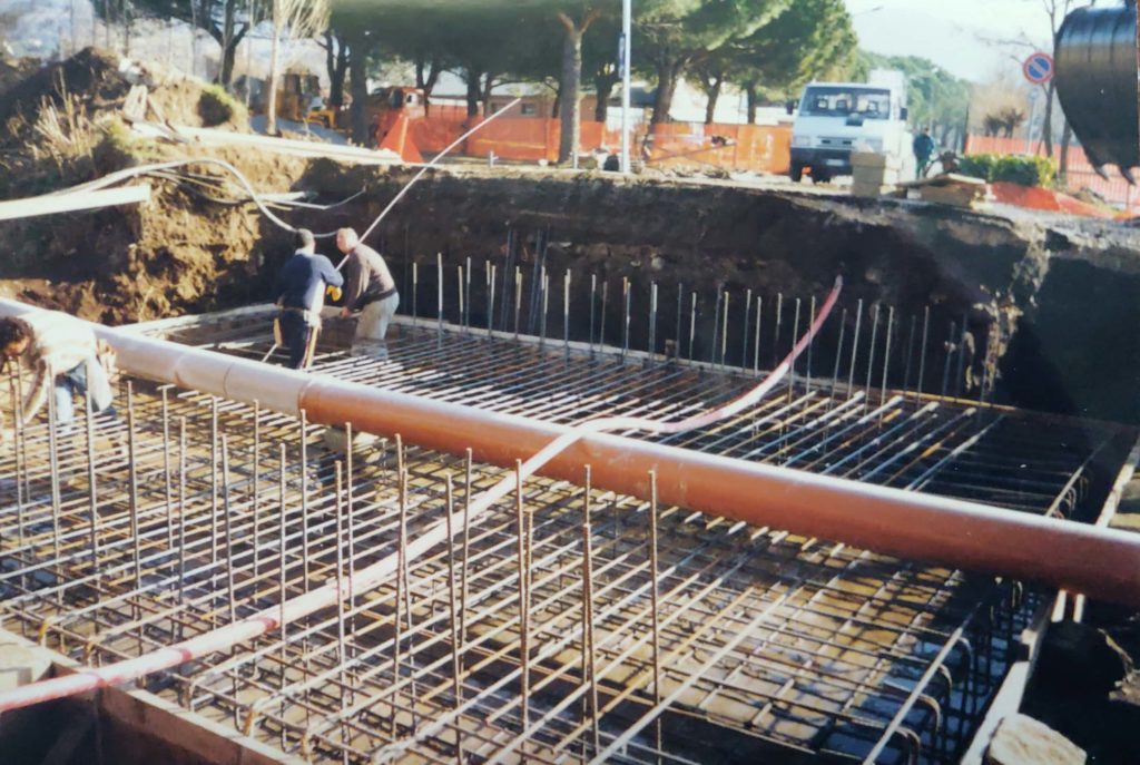 Operai lavorano su una struttura in cemento armato.